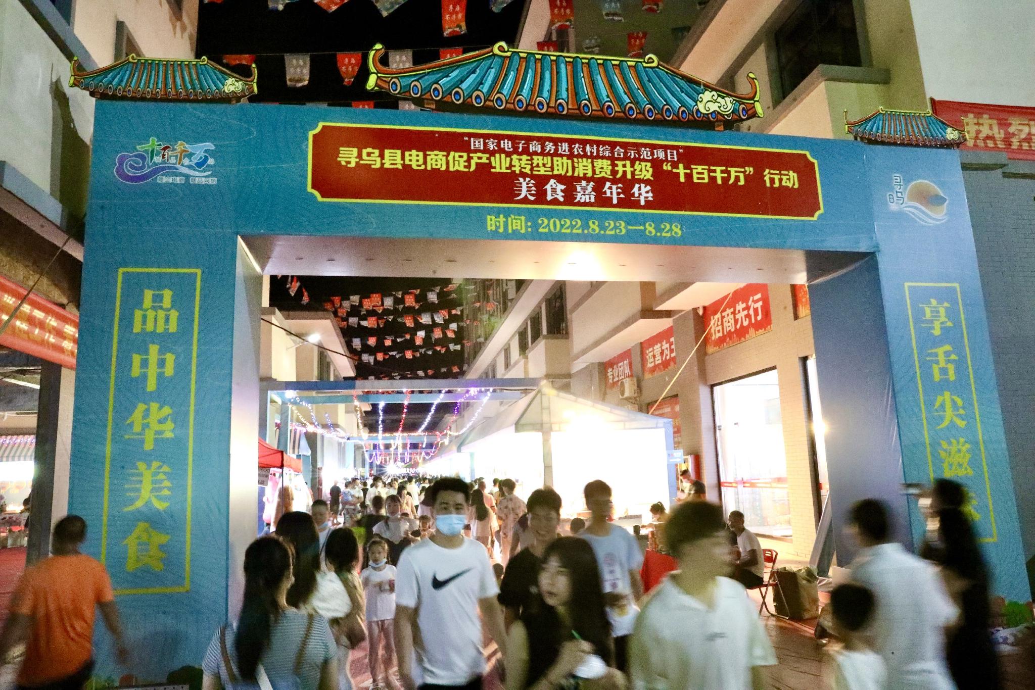 8月27日晚，游客在江西省寻乌县国际商贸城美食嘉年华上游览。中国日报记者 朱兴鑫 摄