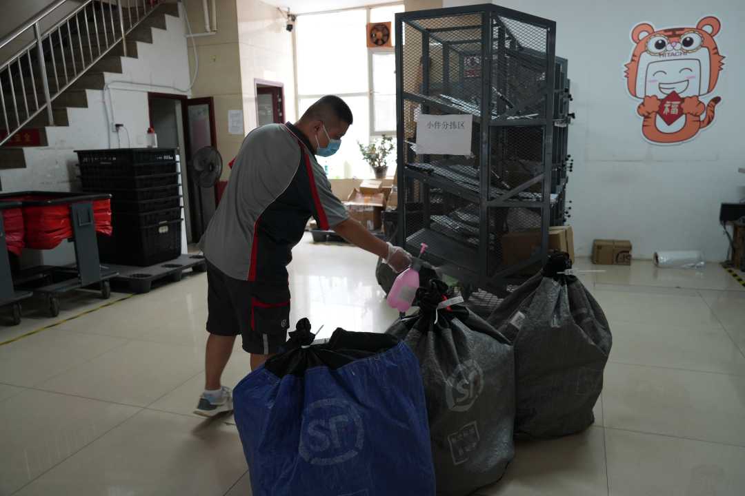 快递员正将寄送快递进行消毒.张明明摄