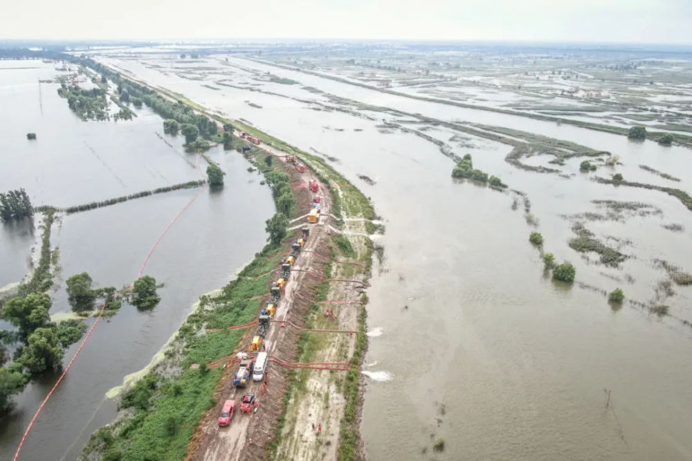 抢险人员在辽宁盘锦绕阳河左岸曾经的河堤溃口北段进行排涝作业。