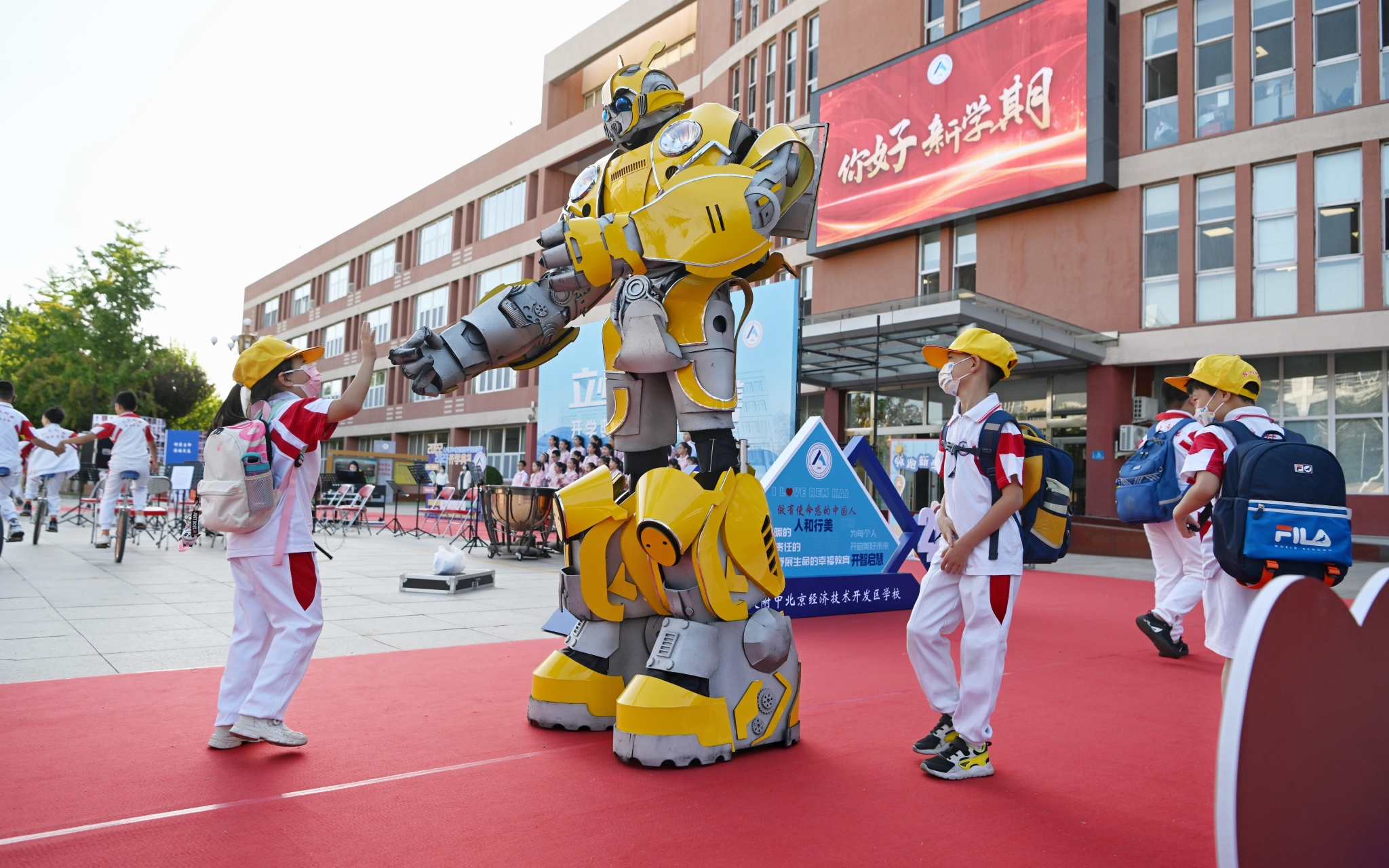 ▲9月1日上午，在人大附中北京经济技术发开区学校门口，“机器人”迎接学生们进校。新京报记者 陶冉 摄