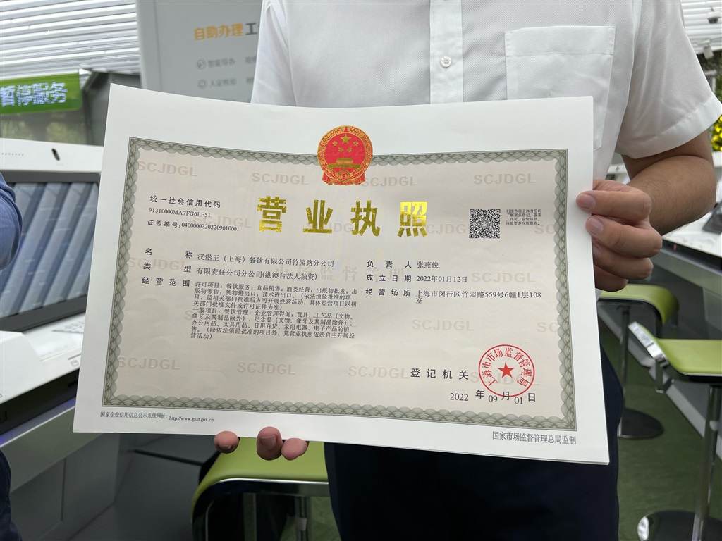 汉堡王相关人员向记者展示标注企业码的营业执照