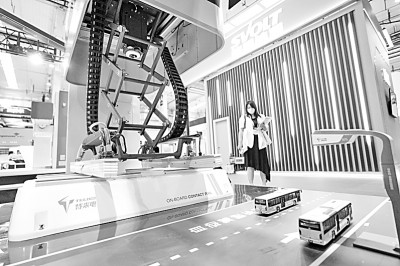 2022世界新能源汽车大会上,一位参观者在参观一款面向无人驾驶自动客车的柔性充电弓。新华社发