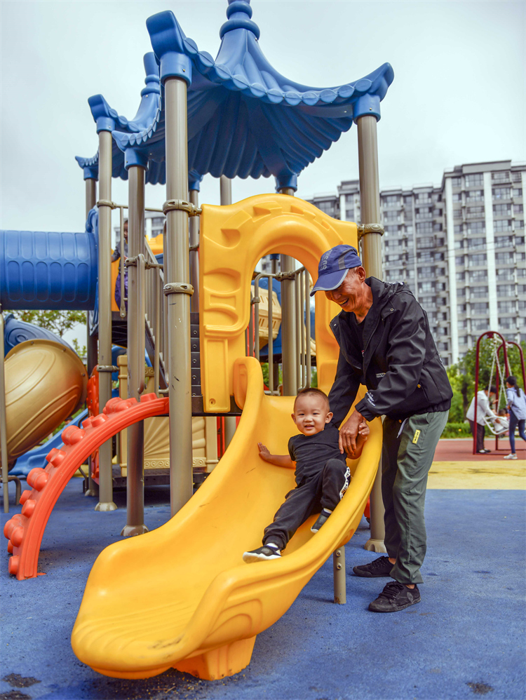 8月29日,家长带着孩子在河北省玉田县一处"口袋公园"的儿童乐园玩耍.