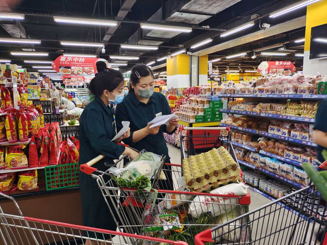 超市内保供人员正在根据订单分拣生活物资.李鹏茹摄