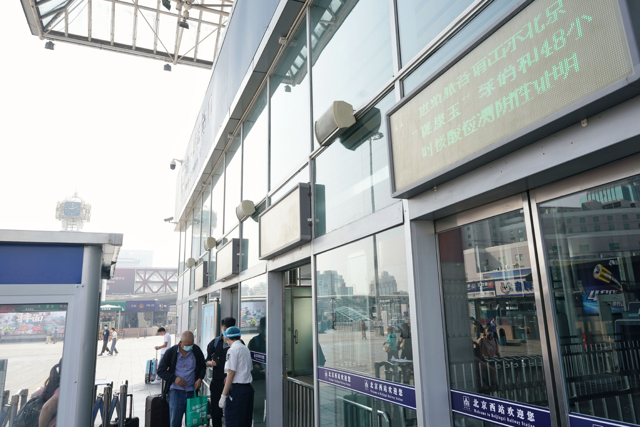 北京西站的户外屏幕上滚动播放着进站需持有健康宝绿码和48小时内核酸