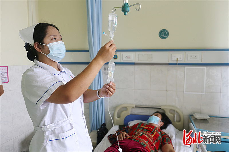抚宁区人民医院护士正在为患者更换输液袋.