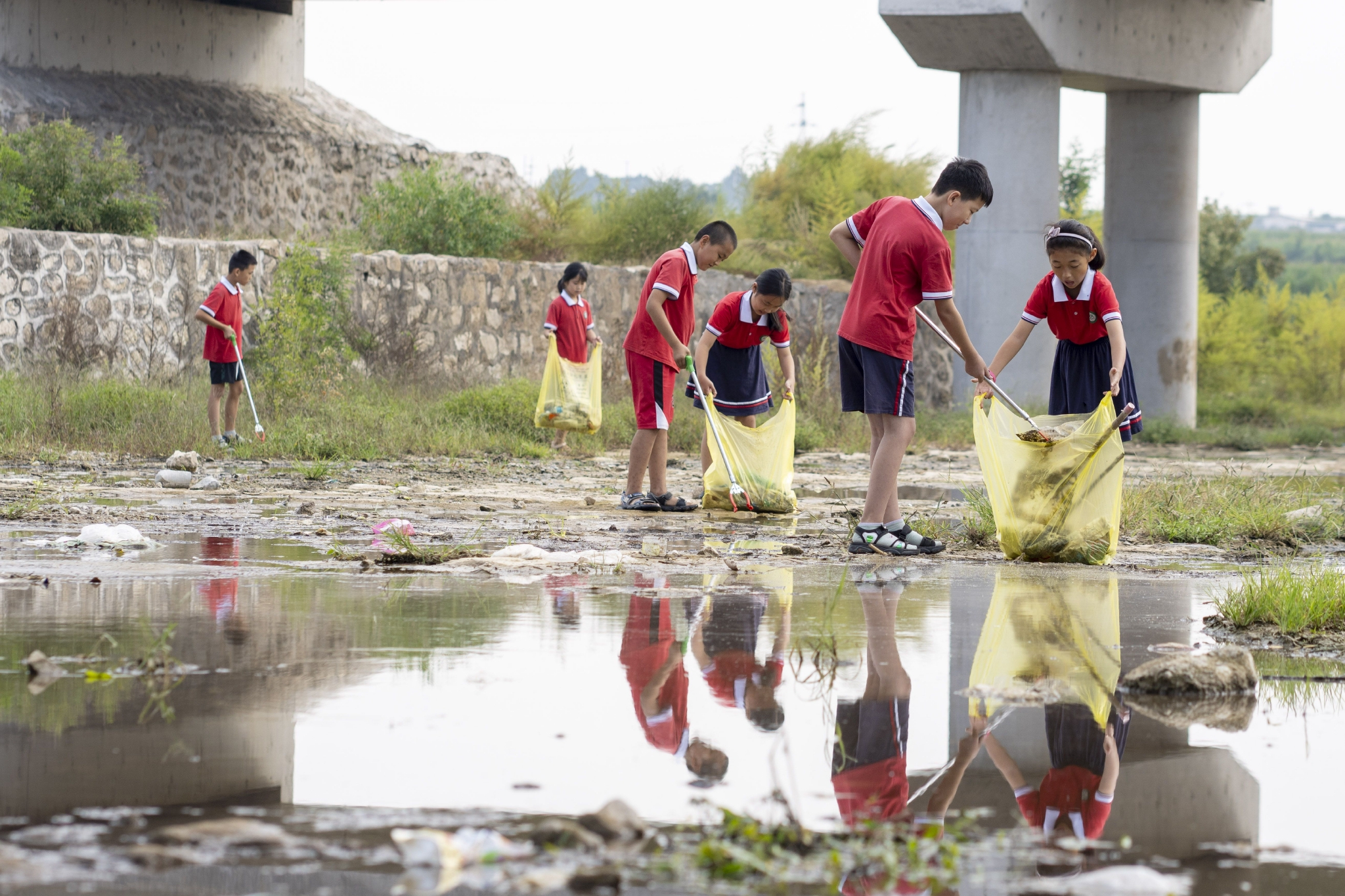 河北省邢台市内丘县柳林镇明德小学学生在一水库周围清理垃圾杂物.