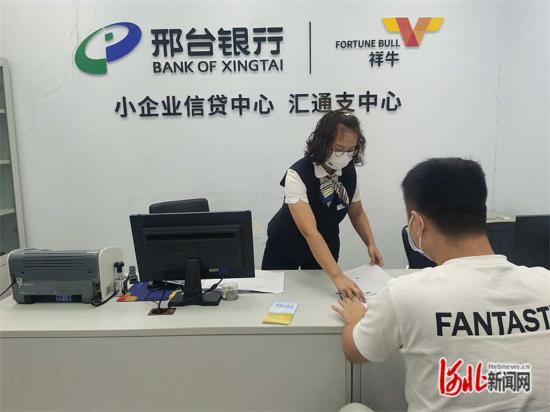邢台银行小企业信贷中心,工作人员正为一家小企业负责人办理相关业务