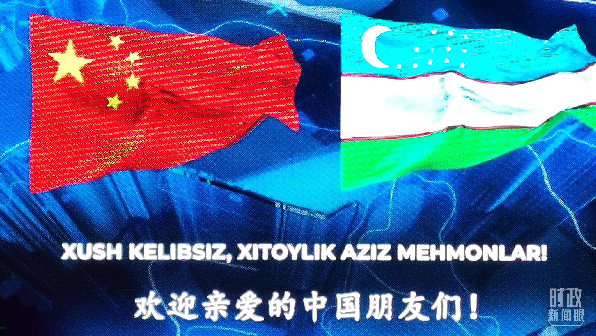 △在撒马尔罕街道上，电子屏幕显示中乌两国国旗和中乌两种语言的欢迎标语。（总台央视记者黄京辉拍摄）
