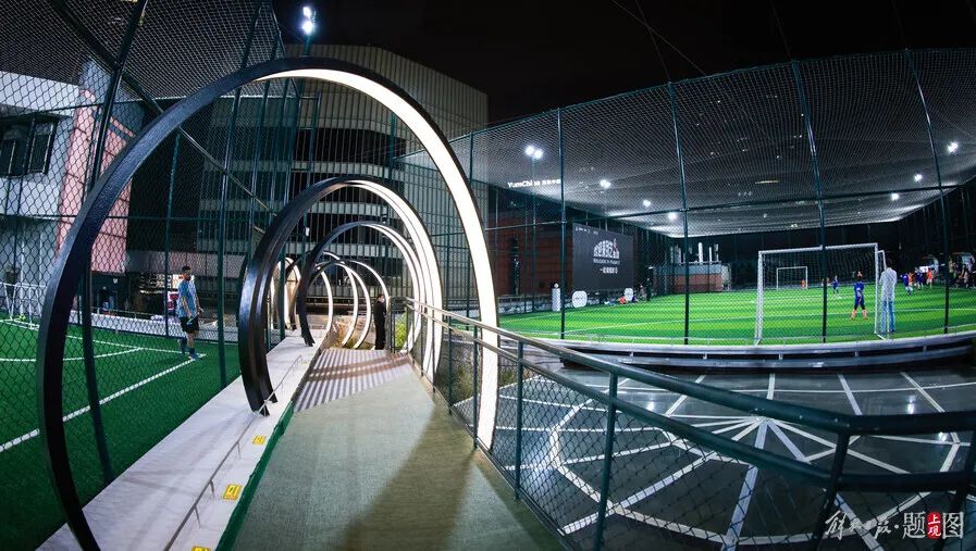 上海市中心新添屋顶足球场,一到夜晚犹如"绿宝石"镶嵌在高楼大厦间.