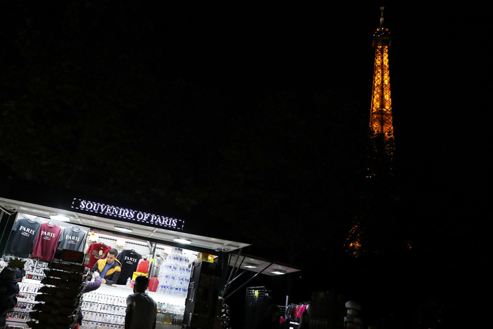 这是9月22日拍摄的亮灯的法国巴黎地标性建筑——埃菲尔铁塔和附近的一家纪念品商店。 新华社记者高静摄