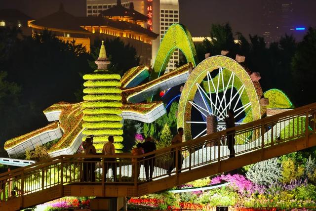 昨晚，在东单路口南侧人行天桥，很多市民驻足观赏“协调发展”花坛。北京晚报记者 邓伟摄