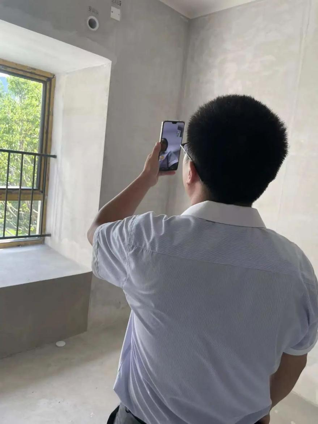 ▲工作人员视频直播房屋情况，配合业主“云交付”