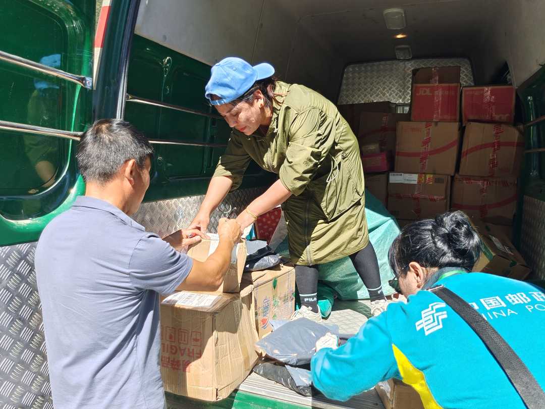 邮政工作人员在林芝市墨脱县背崩乡村里派送邮件. 贺建明 摄