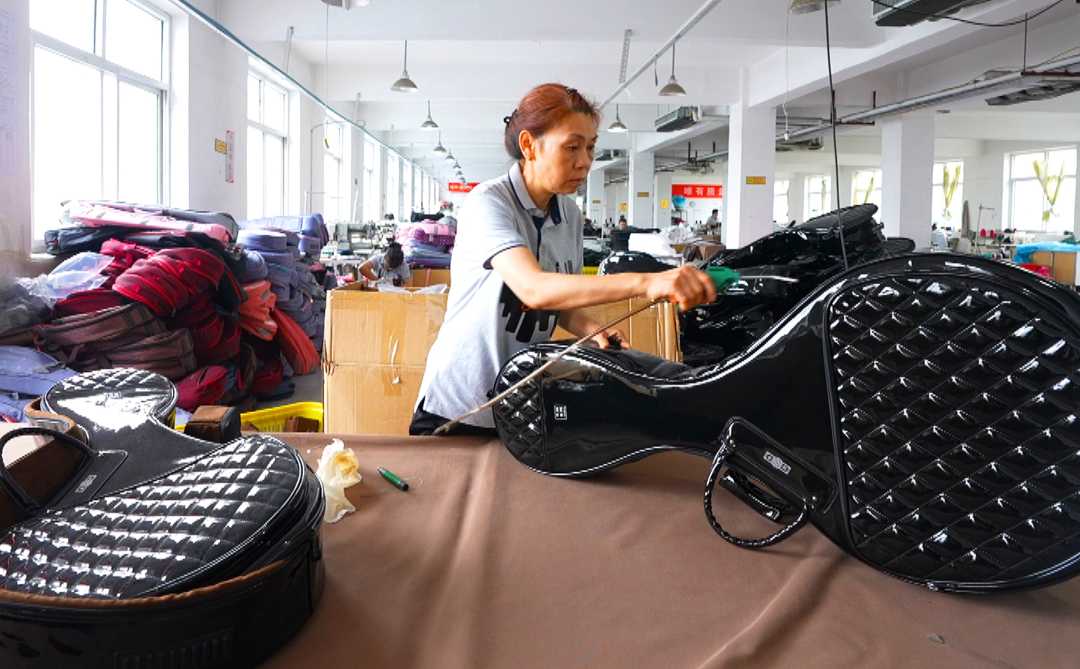 10月5日,员工在白沟新城一家箱包生产企业加工乐器包.