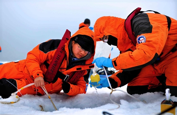 祁第（左）在北极冰站放采水器 受访者供图