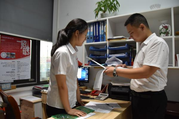 奥士康科技股份有限公司人力资源部经理肖俊(右一)在查看应聘人员信息