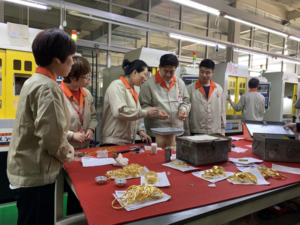 王忠善(左四)在车间里查看生产情况