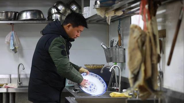 在餐馆打工洗盘子的陈伟. 受访者供图