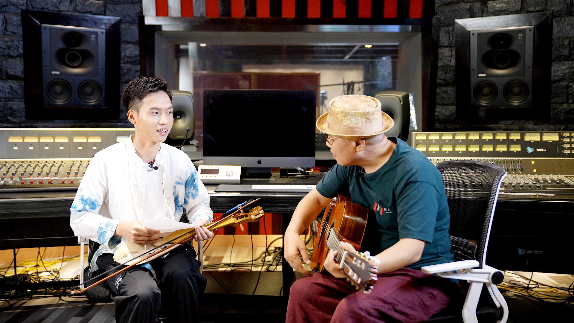 　　侗琵琶与吉他——侗族音乐人吴俊龙(左)与音乐制作人李杰在工作室，节目组供图