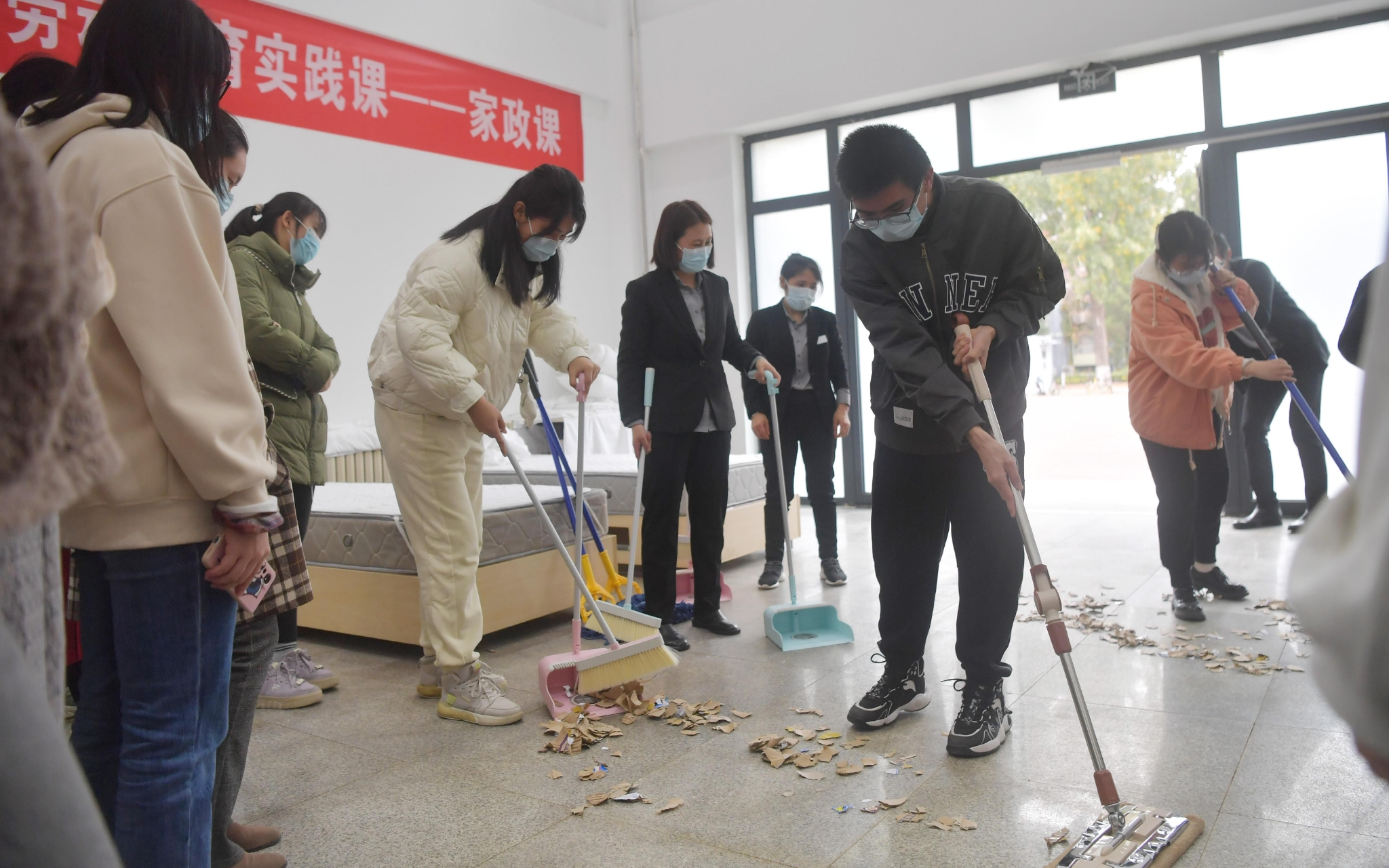 学生们在家政课上练习扫地的技巧. 新京报记者 李木易 摄