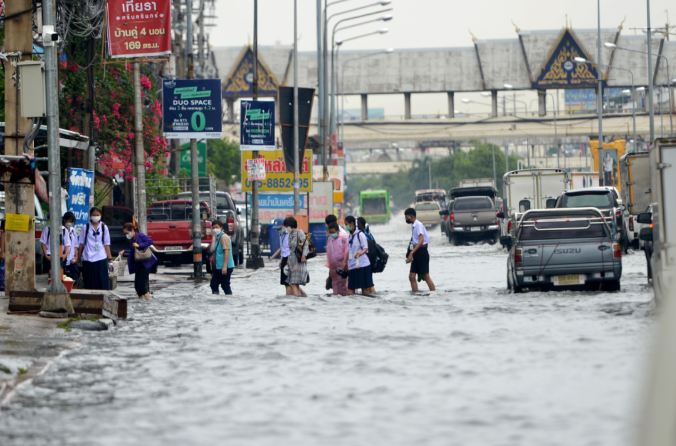 　　2022年9月13日，在泰国曼谷，人们走过积水的街道。（新华社发）