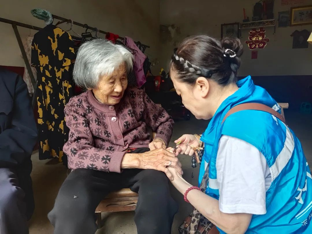 　　湖南湘潭的志愿者们来探望肖德胜烈士母亲,为她修剪指甲。