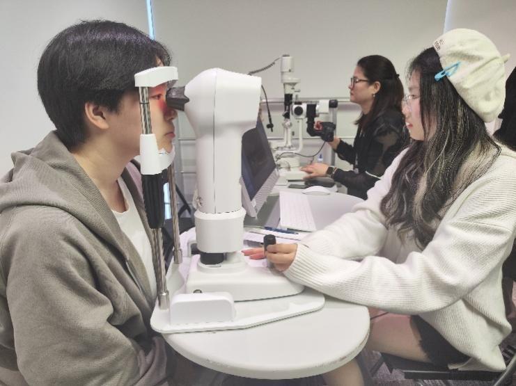 　　给同学进行角膜地形图检查的马惠萍同学
