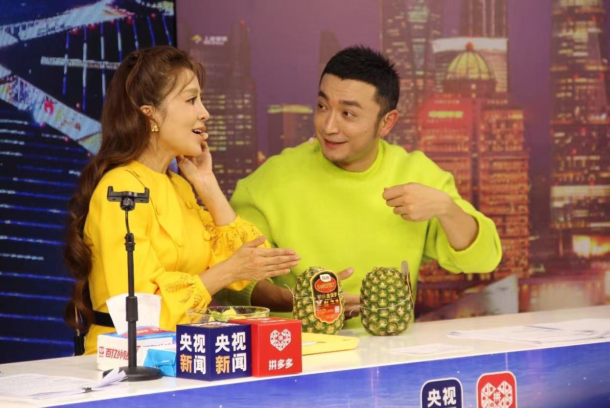 央视主持人朱迅（左）与小尼（右）正在讲解产自菲律宾的金菠萝。张伟 ▏摄
