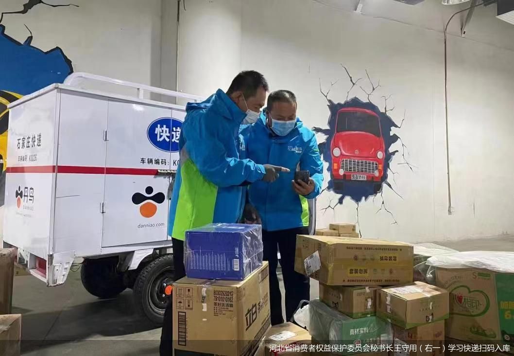 河北省消费者权益保护委员会秘书长王守用(右一)学习快递扫码入库