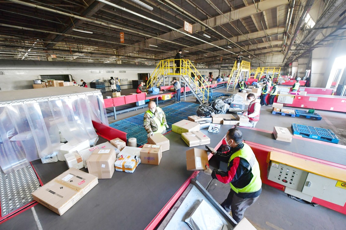 工人们正在将货物取出并搬运到分拣传送带上.记者 常鸣/摄