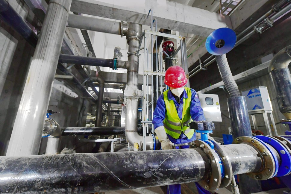 工人正在进行管道连接及相关设备安装.记者 常鸣/摄