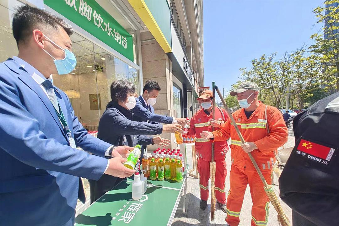 　　北京链家1400余家门店全部建成“户外劳动者暖心驿站”。图为链家工作人员为路过的环卫工人发送饮品。