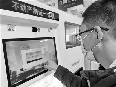 市民在操作自助打证机打印不动产权证.