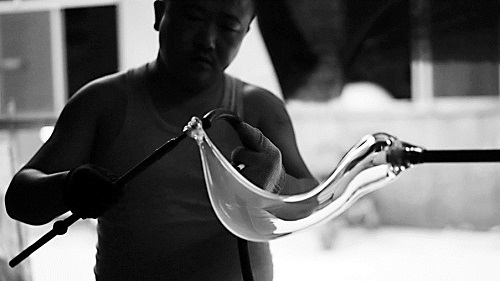 在山西祁县的工厂，玻璃工匠正在吹制醒酒器。 秦晓茜/摄