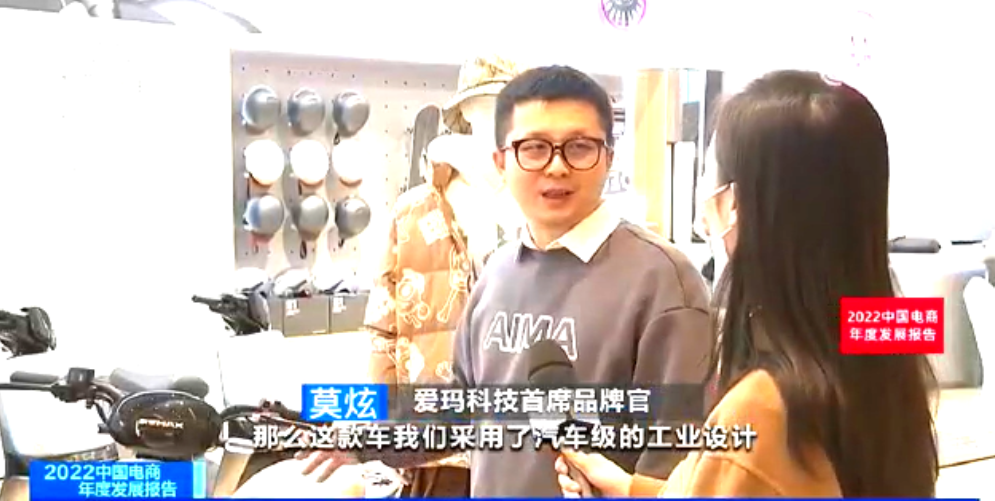 　　图：爱玛科技首席品牌官莫炫向记者介绍爱玛引擎芯动力时尚好车