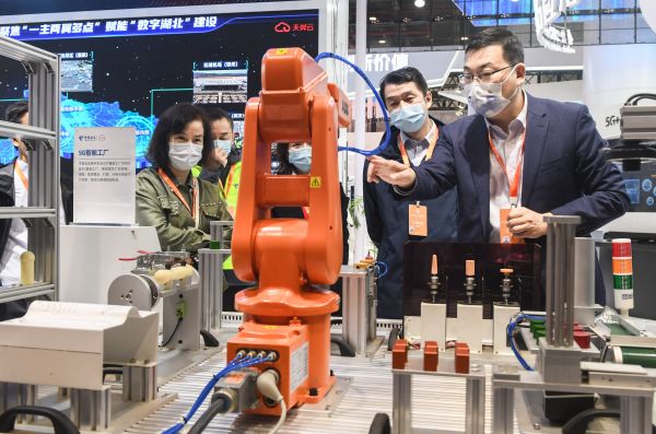 11月20日，在湖北武汉举办的2022中国5G+工业互联网大会期间，工作人员向参观者介绍5G智能工厂生产场景。（程敏 摄）