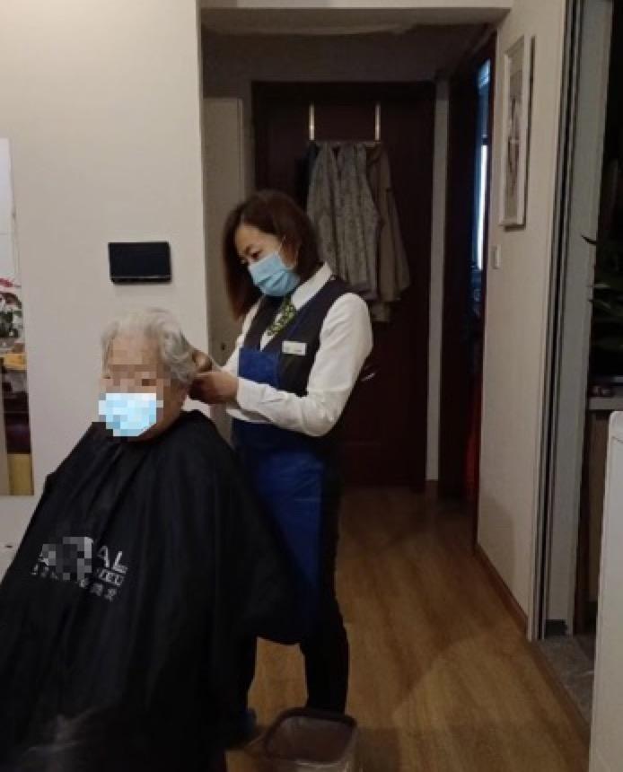 西翠佳苑万科物业管家经理张丽霞正在为老人理发。受访者供图