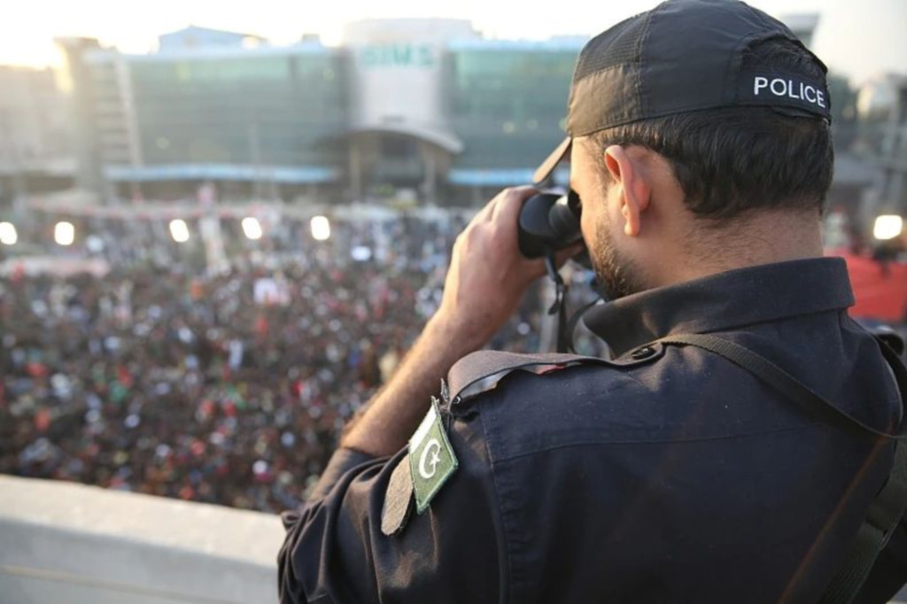 当地时间11月26日，巴基斯坦拉瓦尔品第，一名警察正在观察集会人群。图/视觉中国