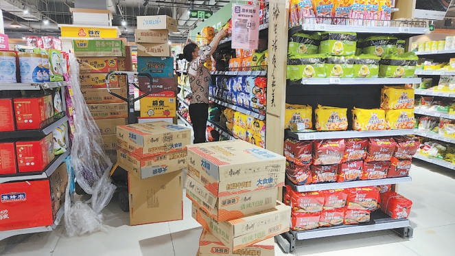 物美超市大成路店的理货员正忙着往货架上补货.徐伟摄