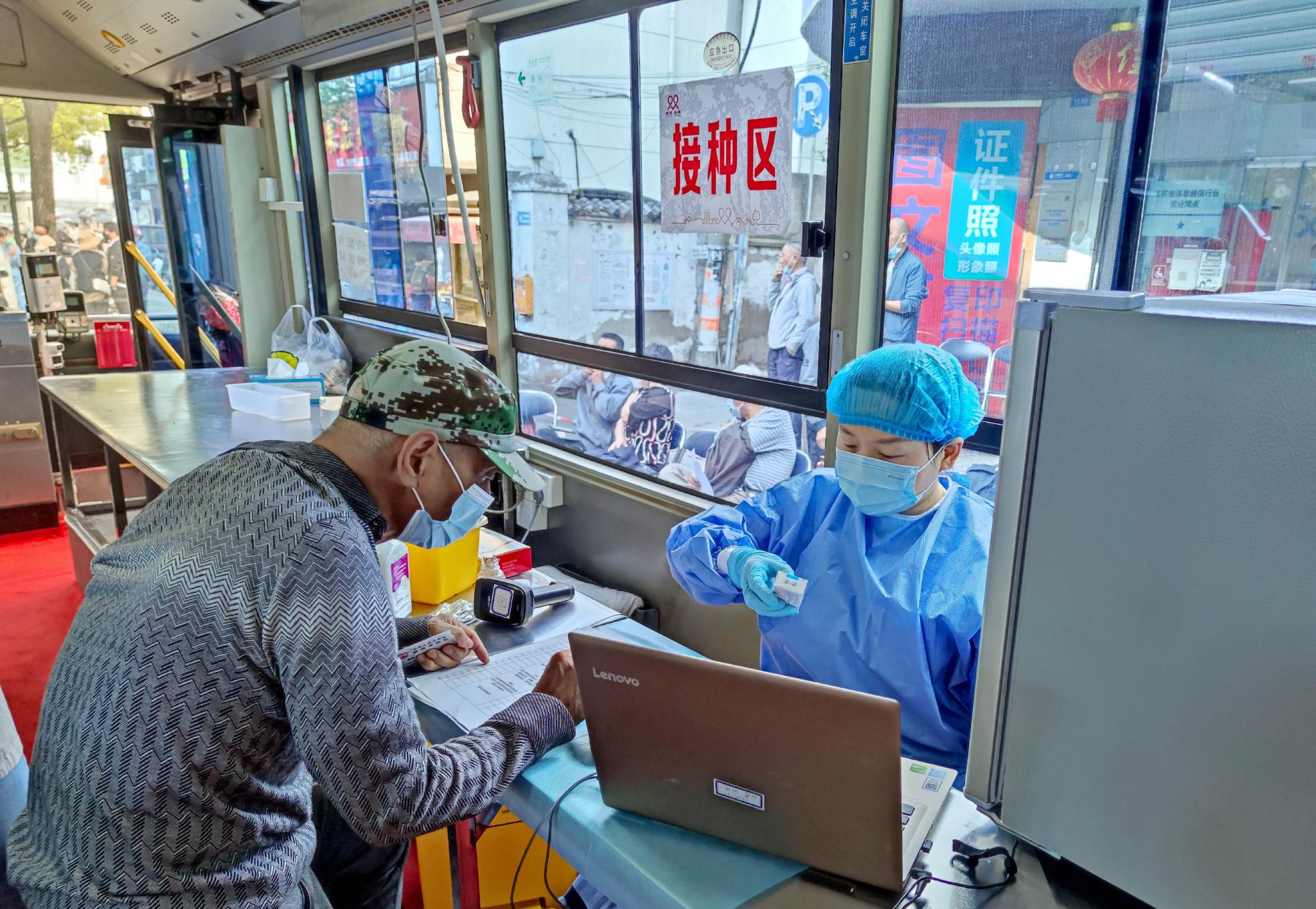 2022年5月21日，江苏省苏州市姑苏区双塔街道老年居民在流动疫苗接种车上接种新冠疫苗。图/IC photo
