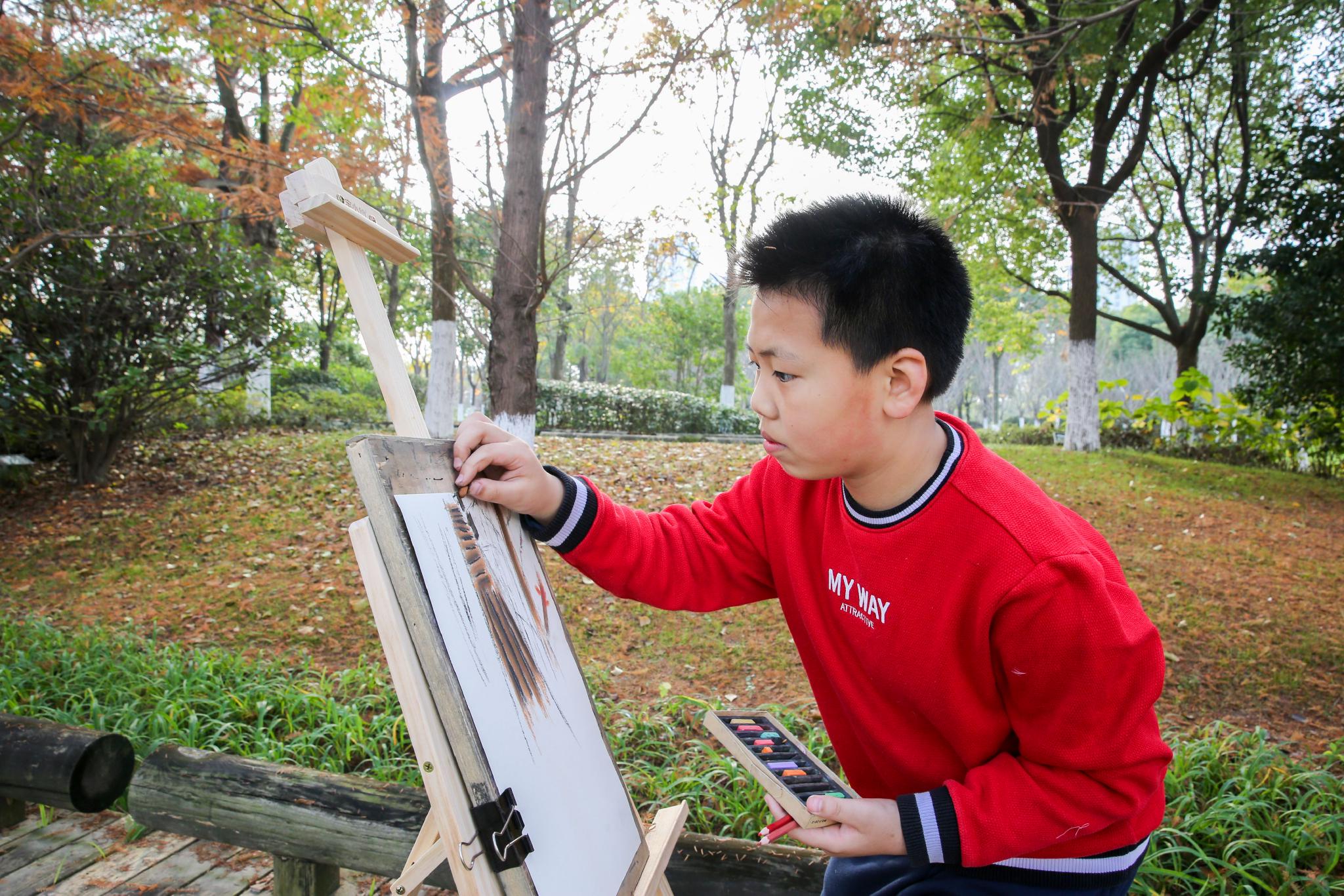 小学生来到龙游河生态公园内赏景写生.通讯员 徐慧 摄