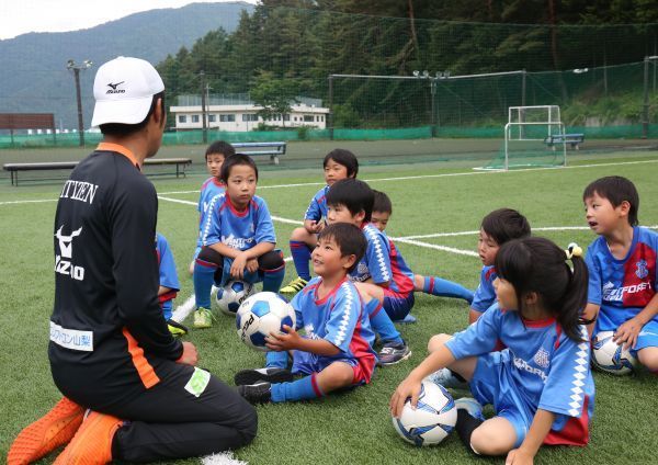 日本“甲府风林队”的球员指导当地儿童踢球 图片来源：参考消息