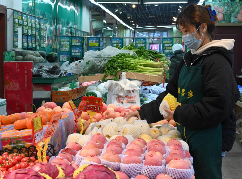 11月28日,店员在乌鲁木齐市南湖南路西二巷的一家水果店内整理货品.