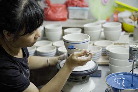 潮州陶瓷的发展初期，当地的生产模式以手工作坊为主，图为匠人正在为素胚上色。企业供图