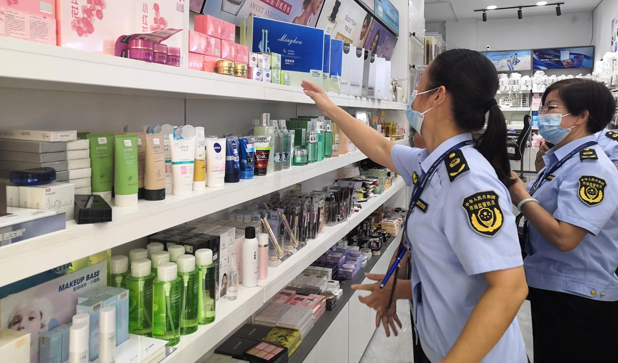 执法人员对当事人经营场所内的化妆品进行检查.灵山县市场监管局供图