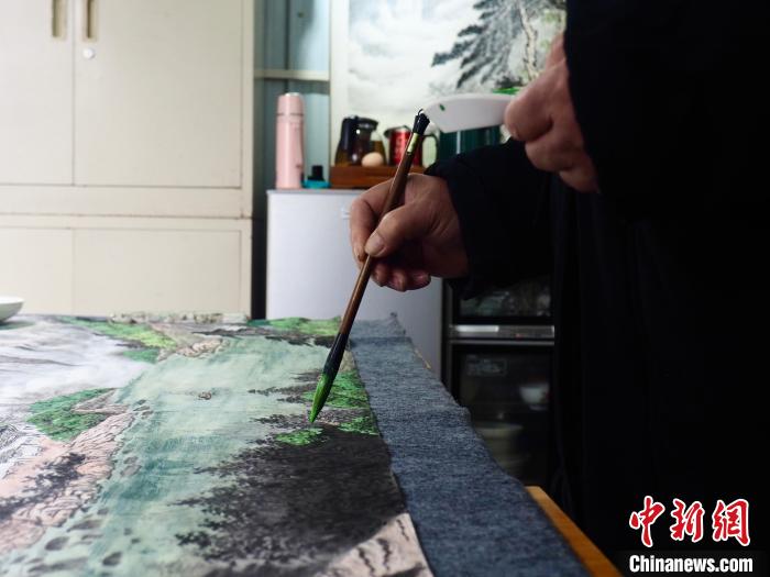 图为一位因车祸致残的残疾人在作画，其成品多在旅游景点售出。李娇阳 摄