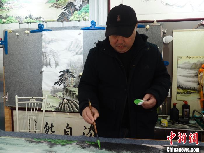 柳州市残疾人就业困难人员创业基地里，一位因车祸致残的残疾人在作画。李娇阳 摄