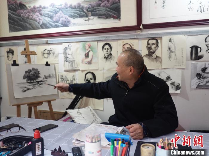 柳州市残疾人就业困难人员创业基地里，一名残疾人在介绍自己的作品。李娇阳 摄