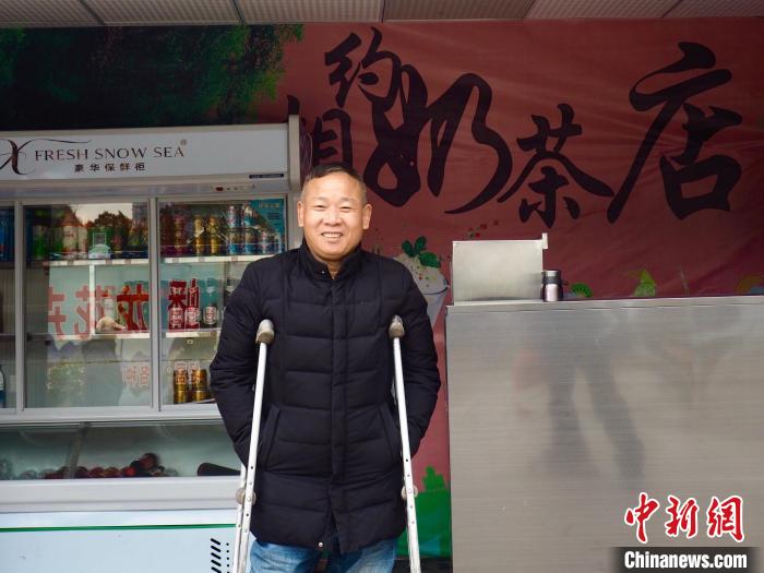 12月2日，广西柳州市残疾人就业困难人员创业基地里，一位残疾人在奶茶店里迎接客人。李娇阳 摄